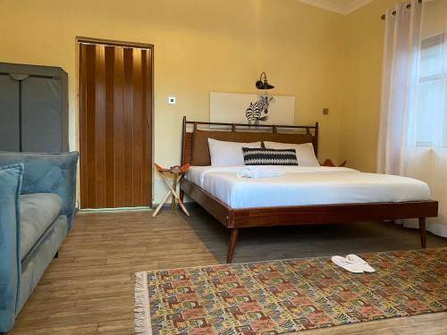 a bedroom with a large bed and a couch at Emirishoi Cottages and Garden Bistro in Narok