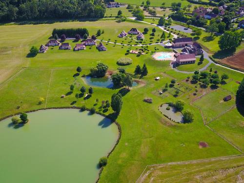 - une vue aérienne sur un grand domaine avec un étang dans l'établissement Gîtes Les SOURCES, à Hautefort