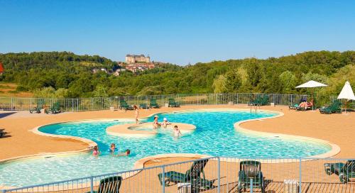 un groupe de personnes dans une piscine d'un complexe hôtelier dans l'établissement Gîtes Les SOURCES, à Hautefort