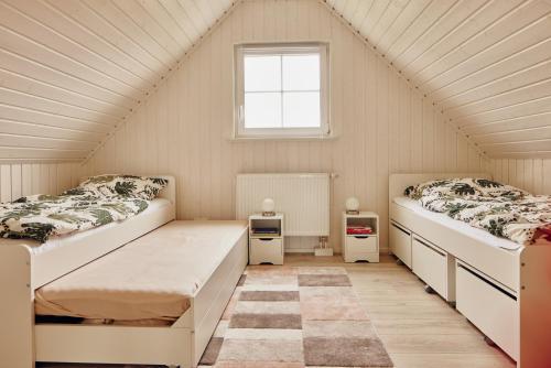 two beds in a small room with a window at Familienhaus in der Schorfheide in Wandlitz