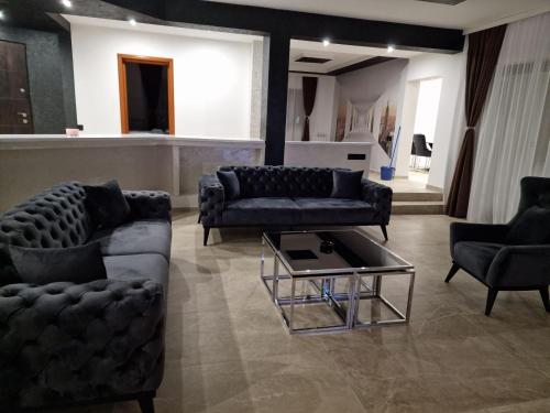 a living room with couches and a coffee table at Hedonic Wellness Apartmani in Niš