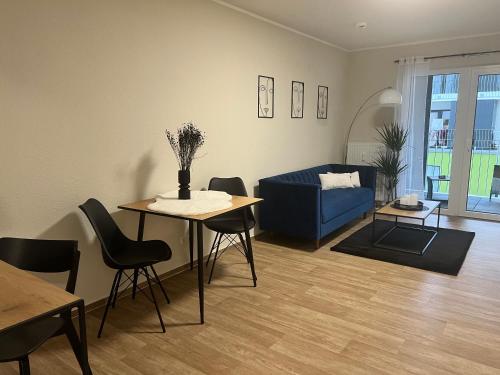 - un salon avec un canapé bleu et une table dans l'établissement Charming Homes - Studio 10, à Wolfsburg