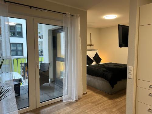 - une chambre avec un lit et une porte coulissante en verre dans l'établissement Charming Homes - Studio 10, à Wolfsburg