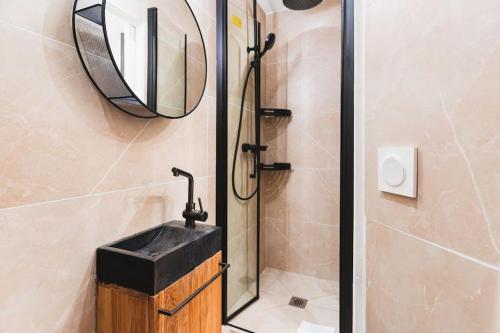 une salle de bain avec un lavabo et un miroir dans l'établissement Nouveau-Luxueux Appartement-4P, à Paris