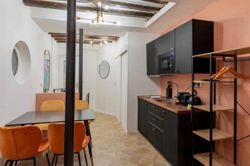 une cuisine avec une table et des chaises orange dans l'établissement Nouveau-Luxueux Appartement-4P, à Paris