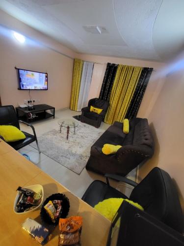 a living room with two couches and a tv at G&G Homes Pipeline Nakuru in Nakuru