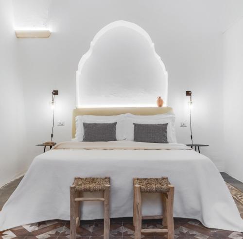 a white bedroom with a large white bed with two tables at Palais Gentile Matino in Matino