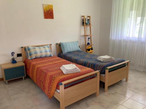 1 dormitorio con 2 camas individuales y una guitarra en La Casetta, en Pombia