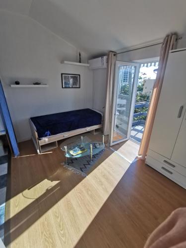 a room with a bed and a glass table at Studio i Apartman Ema in Rijeka