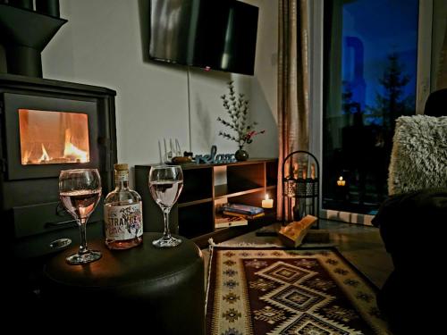 two glasses of wine sitting on a table in a living room at Apartman ALTA in Vlasic