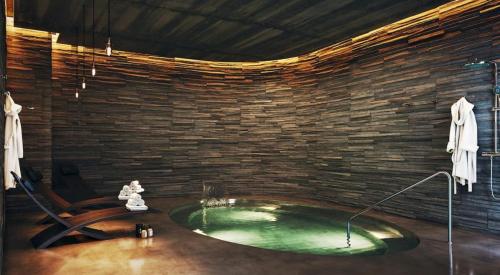 een badkamer met een bad in een stenen muur bij Apartment in Emblematic Building in Canet de Berenguer