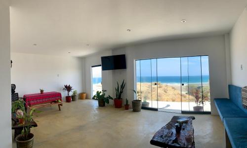 a living room with a view of the ocean at Tayta Surf House in Lobitos