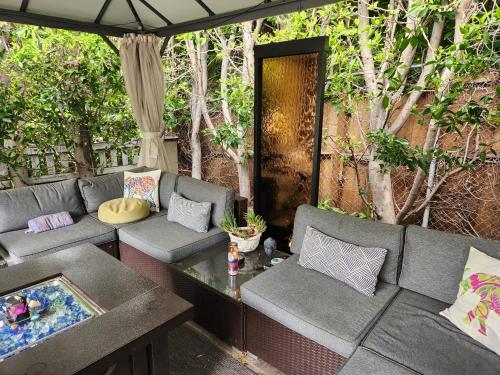a patio with couches and a table and trees at Tranquility at the House of Alchemy Hollywood in Los Angeles