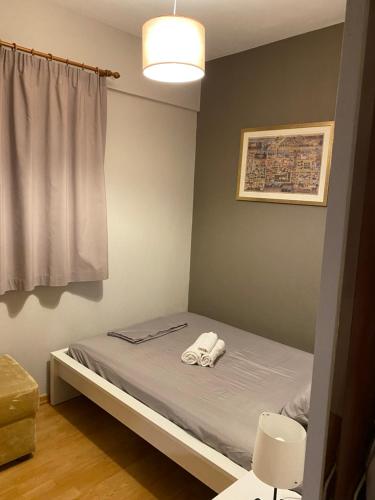een slaapkamer met een bed met twee handdoeken erop bij 2DOORS & Free Parking in Larisa