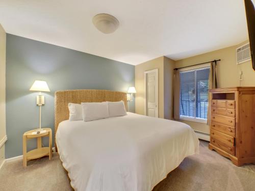 um quarto com uma grande cama branca e uma janela em 104 Pointes North Inn em Charlevoix