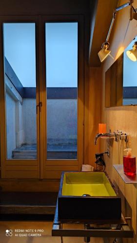 baño con lavabo verde y ventana en Casa Baladin camere di Charme e Agronidi dell'Open Garden en Piozzo