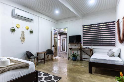 1 dormitorio con 1 cama, escritorio y TV en El Deseo Serendipity Tortuguero, en Tortuguero