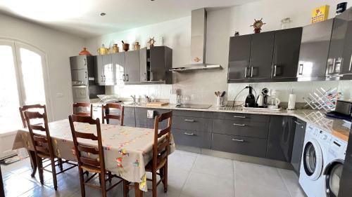 une cuisine avec une table et des chaises dans une cuisine dans l'établissement Superbe villa d'architecte avec piscine chauffée, à Loix