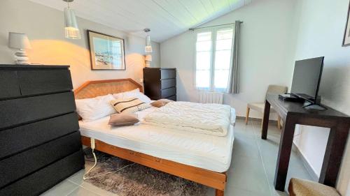 a small bedroom with a bed and a desk at Superbe villa d'architecte avec piscine chauffée in Loix