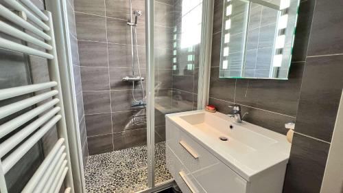 a bathroom with a sink and a shower at Superbe villa d'architecte avec piscine chauffée in Loix