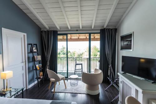 a bedroom with a view of a balcony at HOTEL restaurant CÔTE GARONNE le BALCON DES DAMES - Tonneins Marmande Agen - chambres climatisées in Tonneins