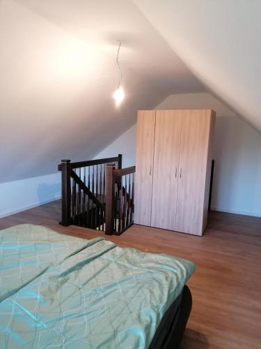 a bedroom with a bed and a wooden cabinet at Gemütliche Wohnung auf 2 Etagen in Lengerich