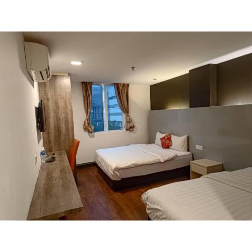 Habitación de hotel con 2 camas y ventana en Sakura Elite Kuala Lumpur, en Kuala Lumpur