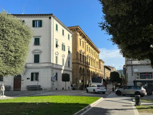 una calle de la ciudad con coches estacionados frente a los edificios en Casa i Portici, en Arezzo