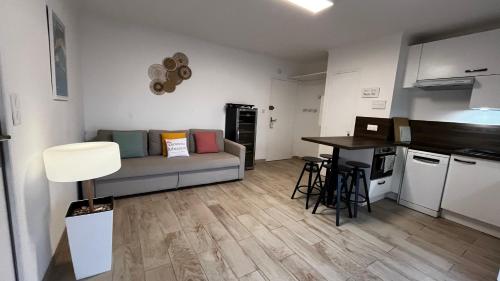 a living room with a couch and a table at Vacances Arbanaises - Appartements Giens in Hyères