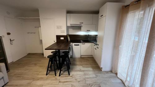 a kitchen with a counter and stools in a room at Vacances Arbanaises - Appartements Giens in Hyères