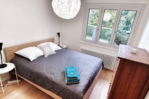 a blue bag sitting on a bed in a bedroom at Maison du Jonc, Genève-Aéroport in Geneva