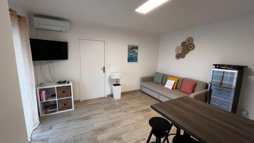 イエールにあるVacances Arbanaises - Appartements Giensのソファとテーブルのあるリビングルーム
