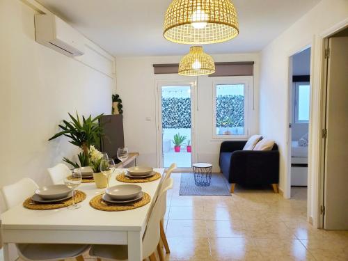 een eetkamer en een woonkamer met een tafel en stoelen bij Apartamento céntrico con patio privado in Tarragona