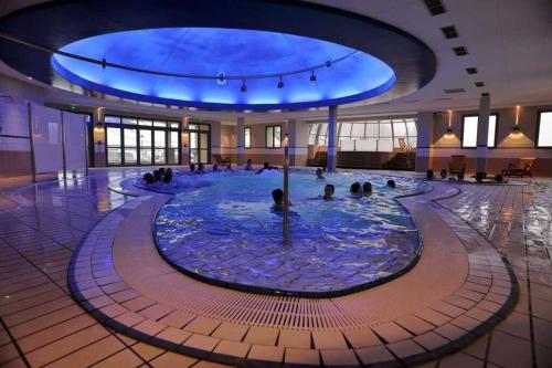 une piscine d'eau avec des personnes dans un bâtiment dans l'établissement Charmant appartement à flanc de montagne, à Barèges