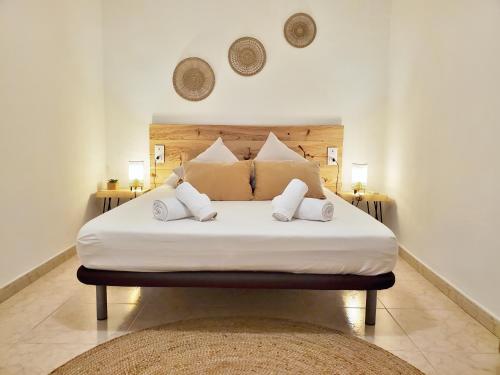 een slaapkamer met een bed met witte lakens en kussens bij Apartamento céntrico con patio privado in Tarragona