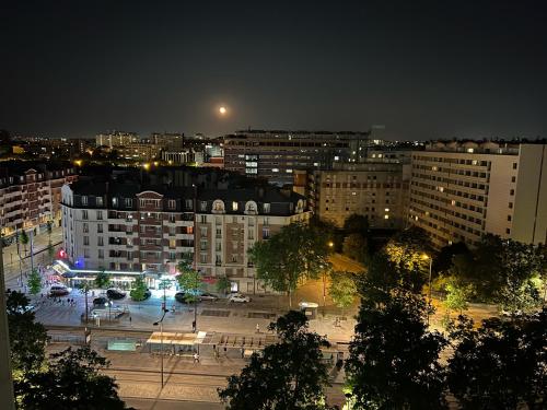 a view of a city at night with buildings at Guest room in a shared apartment - Metro 7 and Tramway T3a in Paris