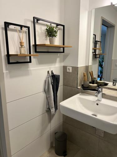 a white bathroom with a sink and a mirror at Charming Homes - Studio 16 in Wolfsburg