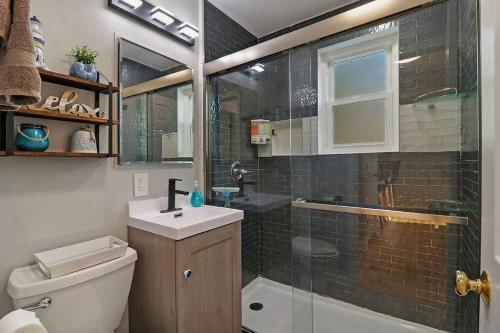 y baño con aseo, lavabo y ducha. en Cute & Cozy 2/1 Lakeview House on Chain O Lakes, en Fox Lake