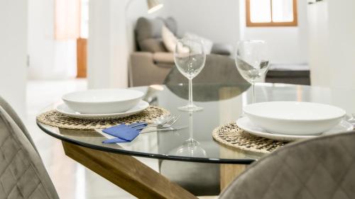 una mesa de cristal con dos platos y vasos. en Catalina Suites Apartments Downtown Valencia, en Valencia