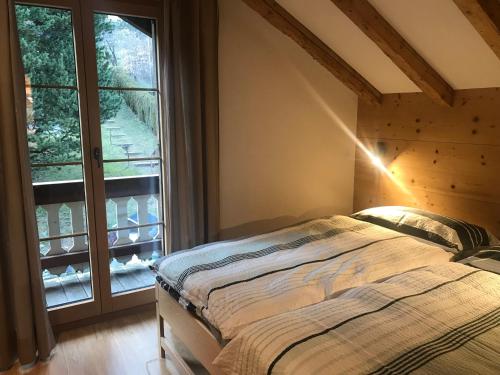a bedroom with a bed and a large window at Chalet Ancienne Poste in Champéry
