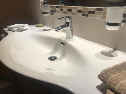 a white bathroom sink with a faucet and towels at Chalet Ancienne Poste in Champéry