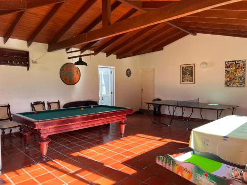 een kamer met een pooltafel en twee tafels bij Hacienda San Pedro Claver Subachoque in Subachoque