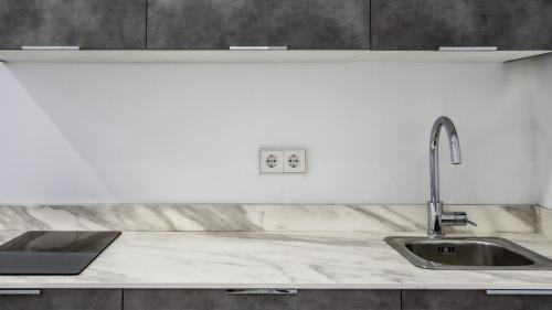 cocina blanca con fregadero y encimera en Catalina Suites Apartments Downtown Valencia en Valencia