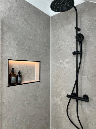 y baño con ducha con cabezal de ducha. en Design-Suite Am Markt, en Pirna