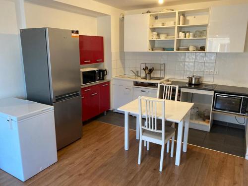 a kitchen with a table and a refrigerator at Appartement 3 pièces AlfortVille Centre in Alfortville