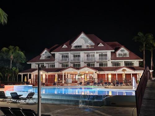 a large hotel with a swimming pool at night at Ti Coco Luce résidence Pierre&Vacances in Sainte-Luce