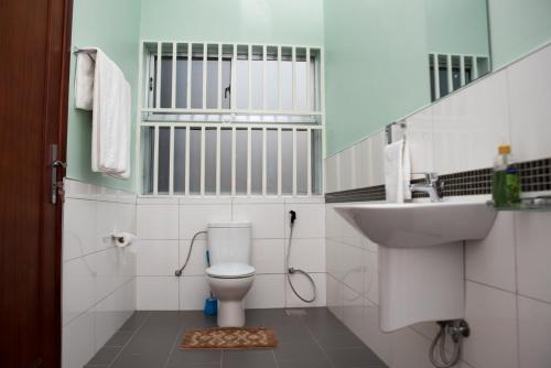 a bathroom with a toilet and a sink at The Pearl Cottages in Kampala
