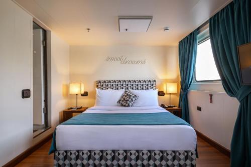 a bedroom with a large bed with green curtains at M/Y Alexander The Great Nile Cruise - 4 Nights Every Monday From Luxor - 3 Nights Every Friday from Aswan in Luxor