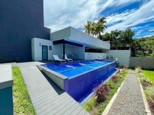 a swimming pool in the backyard of a house at Sky Flat Panoramic View 2Brm@Avitat Link w/Pool &Gym in Antiguo Cuscatlán