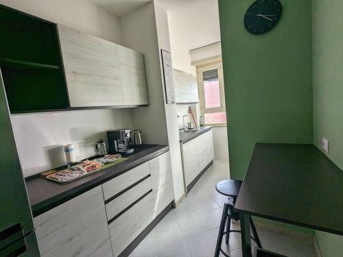 a kitchen with a table and a clock on the wall at SyrakaHost Intero appartamento in Rome